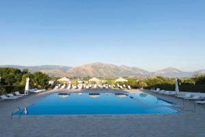 a large pool with chairs and mountains in the background at Dolce Vita Relais in Sala Consilina