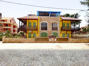 uma casa amarela e verde ao lado de uma rua em Sal Service - Beach residence em Santa Maria