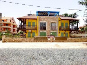a yellow and green house on the side of a street at Sal Service - Beach residence in Santa Maria