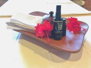 a wooden shelf with two bottles of soap and red flowers at Yacumaman Sanctuary in Tarapoto