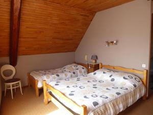 a bedroom with two beds and a wooden ceiling at Hotel Les Chenets in Saint-Julien-en-Champsaur