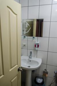 a bathroom with a white sink and a mirror at Venüs Pansiyon in Canakkale