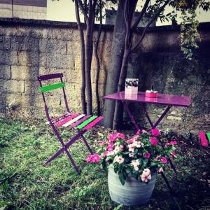 una mesa, una silla, una mesa y una maceta de flores en B&B Parini en Cassino