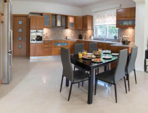 a kitchen with a dining room table and chairs at Villa Epavlis Haraki in Haraki