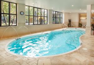 a large swimming pool in a room with windows at The White House in Perth