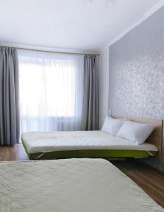 a bedroom with two beds and a window at Scandinavian Poltava Apartments with 2 rooms, 3 beds 1 sofa in Poltava