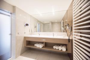 a bathroom with a tub, sink, and mirror at IMLAUER HOTEL PITTER Salzburg in Salzburg