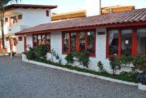 a white building with red windows and plants at Residencial Sol e Mar de Floripa in Florianópolis +8 photos