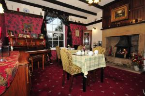 a dining room with a table and a fireplace at Ashtree House Bed and Breakfast in Thornton