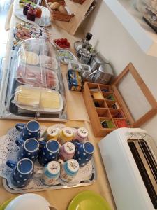 eine Küchentheke mit vielen Speisen und Tassen in der Unterkunft Hotel Appart in Osnabrück