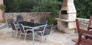 stół, krzesła i kamienny piekarnik w obiekcie Villa Masha w mieście Omišalj