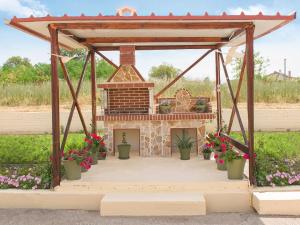 una chimenea en un pabellón con flores y plantas en Villa Elaia Mare, en Fanárion