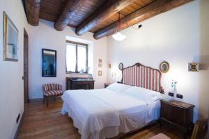 a bedroom with a white bed and a wooden ceiling at Casa Visnenza Bed & Breakfast in Capo di Ponte