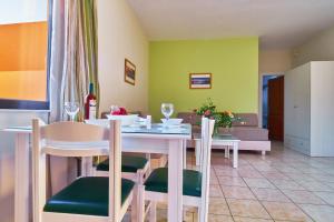 a dining room with a white table and chairs at Nanakis Beach Apartments in Stavros