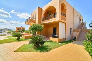a villa with a view of a building at Nanakis Beach Apartments in Stavros