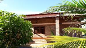 ジジョーカ・デ・ジェリコアコアラにあるRecanto Vendramel Bezerraの小さなレンガ造りの家で、窓と木々が備わります。