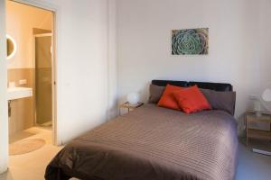 sypialnia z łóżkiem z czerwonymi poduszkami w obiekcie Flora Home w mieście Marina di Carrara