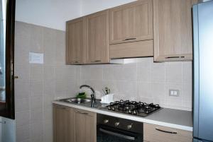 a kitchen with wooden cabinets and a sink and a stove at La Mariposa in Nova Siri