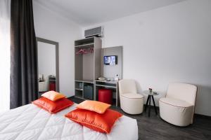 a bedroom with a bed with two chairs and a desk at Hotel Cala Di Forno in Fonteblanda