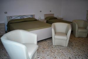 a bedroom with two beds and two chairs at La Mariposa in Nova Siri