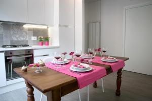 a table with a pink table cloth and glasses of wine at ML House in Costa Volpino
