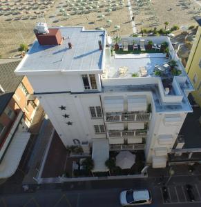 eine Luftansicht eines weißen Gebäudes mit einem Dach in der Unterkunft Hotel Belvedere Spiaggia in Rimini