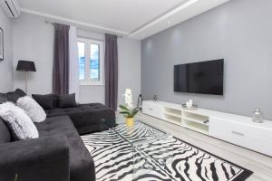 a living room with a couch and a television at Mandalina Suite in Šibenik