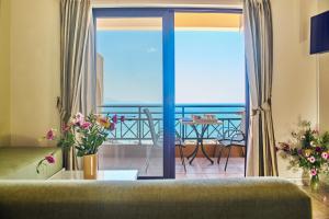 a living room with a couch and a view of the ocean at Nanakis Beach Apartments in Stavros