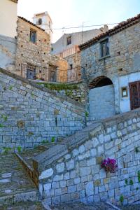 an old stone building with a stone wall at La Mariposa in Nova Siri