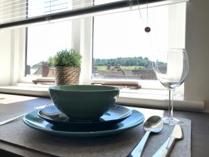 una mesa con un tazón y una copa de vino en Upper Highview - Self Catering Apartment, fpventures Stroud en Stroud