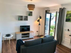 a living room with a couch and a tv at Upper Highview - Self Catering Apartment, fpventures Stroud in Stroud