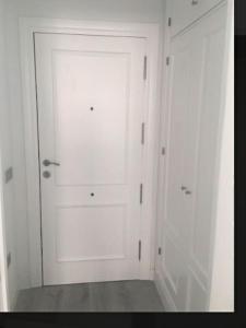 ロケタス・デ・マルにあるBersan2の白いドアと白いキャビネット2つが備わる客室です。