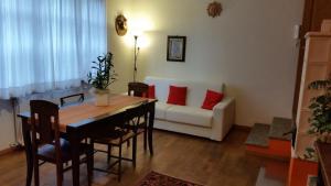 een woonkamer met een tafel en een bank bij La Casa in Collina in Alba