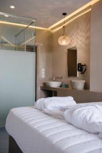 a bedroom with a bed with a sink and a mirror at Argilos in Sidari