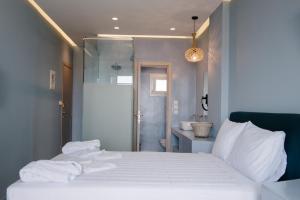 a bedroom with a white bed and a bathroom at Argilos in Sidari