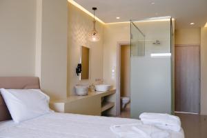 a bedroom with a white bed and a sink at Argilos in Sidari