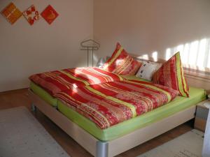 1 dormitorio con 1 cama con edredón verde y rojo en Ferienwohnung Bertolotti, en Achberg