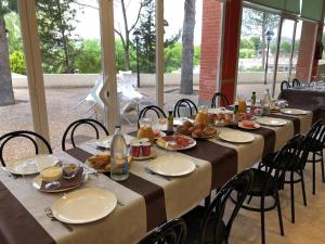 un lungo tavolo con piatti di cibo sopra di Camping Fayón Fishing a Fayón