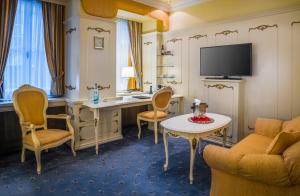 a hotel room with a desk and a television at Schlosshotel Römischer Kaiser in Vienna