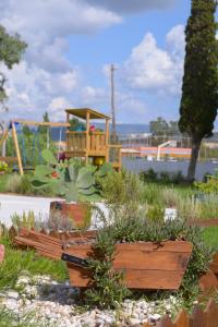a garden with a bench and a playground in the background at Argilos in Sidari
