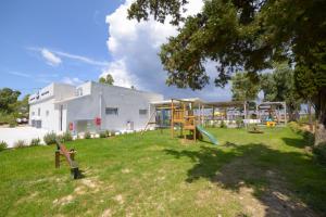 a park with a playground and a white building at Argilos in Sidari