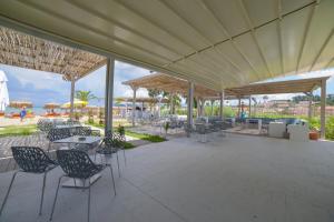 a patio with chairs and tables and a view of the beach at Argilos in Sidari