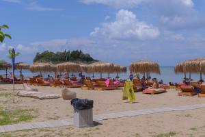 a beach with many chairs and straw umbrellas at Argilos in Sidari