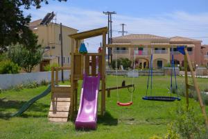 a playground with a slide and swings in a yard at Argilos in Sidari