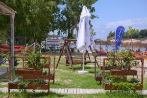 a group of chairs with plants and an umbrella at Argilos in Sidari