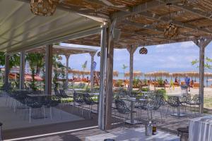 a patio with tables and chairs on the beach at Argilos in Sidari