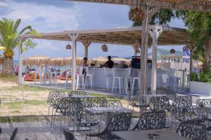 a group of tables and chairs under a pavilion at the beach at Argilos in Sidari