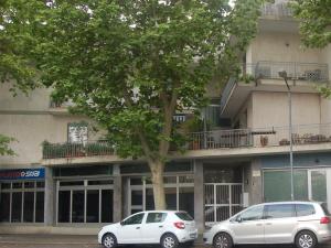 two cars parked in front of a building with a tree at B&B Early Leaving Bergamo Airport in Bergamo