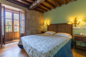 um quarto com uma cama e uma grande janela em Asador de Roxos Casa Albardonedo em Santiago de Compostela