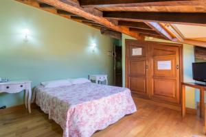 ein Schlafzimmer mit einem Bett und einem TV in einem Zimmer in der Unterkunft Asador de Roxos Casa Albardonedo in Santiago de Compostela